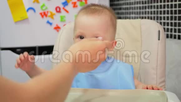 妈妈给婴儿喂食物宝贝在厨房吃食物视频的预览图