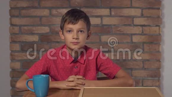 坐在办公桌前的孩子拿着一张挂图背景红砖墙上有刻字的咖啡视频的预览图