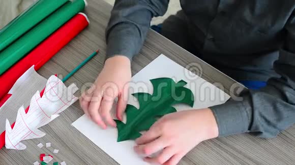 少年男孩用彩纸制作圣诞贺卡视频的预览图