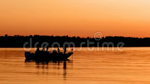 日落后平静的湖面上的渔船剪影视频的预览图