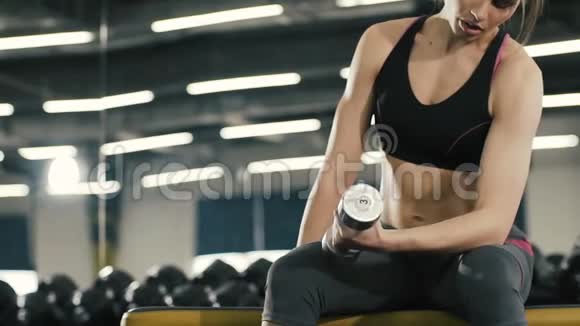 美丽的年轻女孩在健身房背景下用哑弹做运动体育锻炼健康的生活方式肖像画视频的预览图
