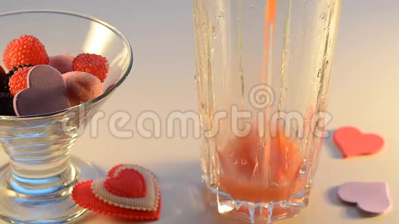 果汁倒一个玻璃糖果花瓶和装饰心有选择的焦点视频的预览图