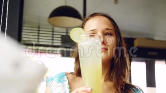 年轻漂亮的女人在咖啡馆里使用智能手机和饮料3840x2160视频的预览图