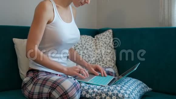 一个金发女人坐在沙发上在电脑前工作视频的预览图