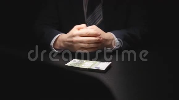 布里伯商人从一张桌子上拿出一捆钱在谈判时间穿上西装欧元视频的预览图