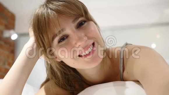 闭上微笑的女人的脸躺在床上视频的预览图