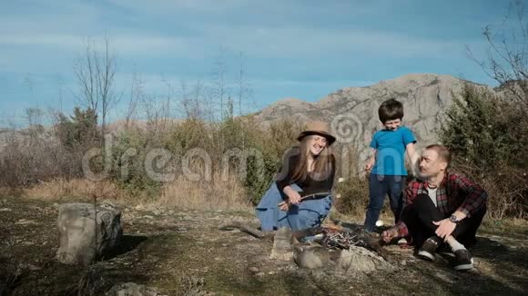 一家人在篝火旁煎Zephyr在大自然户外野餐视频的预览图