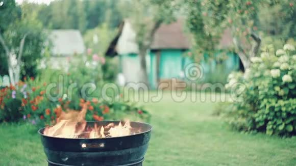 白天在户外在一个圆形的烧烤场烧柴火视频的预览图