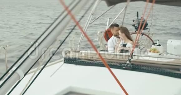 恋爱中的情侣在游艇上放松穿着白色衣服的男人和女人彼此拥抱彼此温柔地享受着旅行视频的预览图