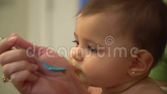 婴儿急切地用勺子吃饭的场景视频的预览图
