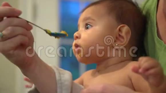 一个女人喂一个漂亮的女婴的场景视频的预览图