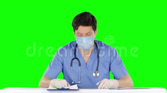 医生摘下医疗手套使用笔记本电脑绿色屏幕视频的预览图