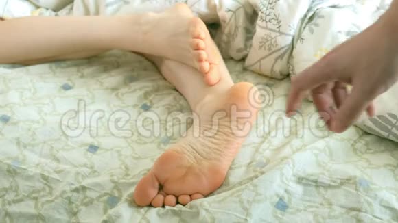 一位慈爱的丈夫叫醒了他的妻子滑稽地挠她的脚视频的预览图