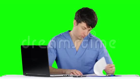 医生用电脑和电话交谈绿色屏幕视频的预览图
