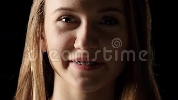 戴着牙套的女人真诚地微笑着黑色视频的预览图