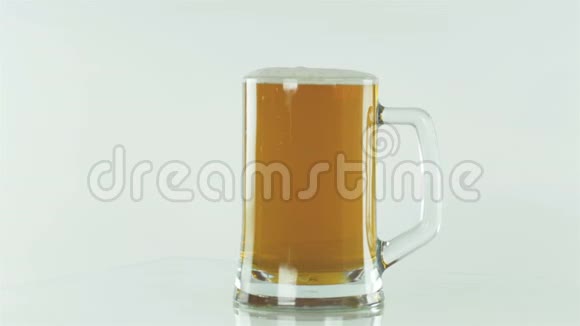 啤酒节一杯啤酒放在白色的背景上泡沫流下来视频的预览图