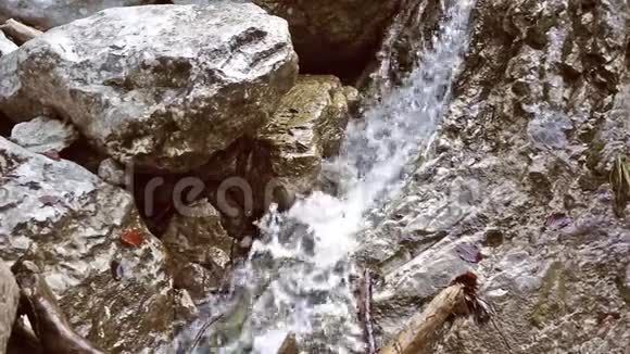 水流缓慢地在石头上落下溪流在石头上落下溅起小山视频的预览图