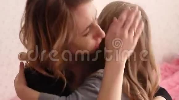 漂亮的母亲抚慰和拥抱哭泣的女婴美丽的年轻母亲安抚哭泣的女儿在家视频的预览图