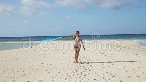 穿丝绸衣服的女孩走在海滩上视频的预览图