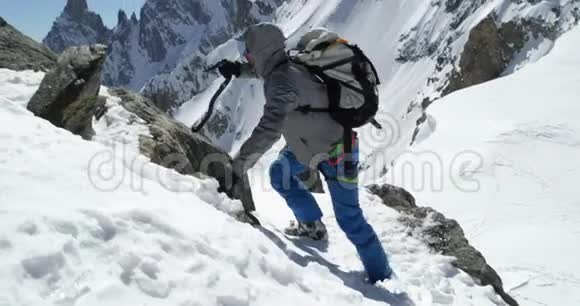 登山者在阳光明媚的日子里用冰斧雪山顶登山滑雪活动滑雪者视频的预览图