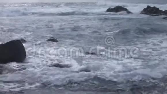 海浪拍打岸边的小岩石视频的预览图