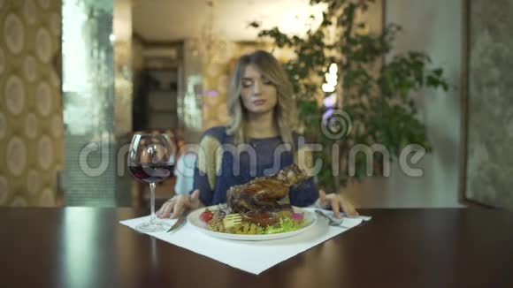 漂亮的纹身女孩年轻的女人等着在高档餐厅用手吃一大块炸肉视频的预览图