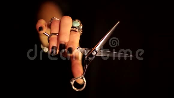 专业女理发师理发师手动剪刀剪在黑色背景下的空中切割运动视频的预览图