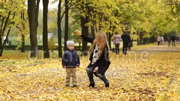 快乐的母子在秋天公园玩耍视频的预览图