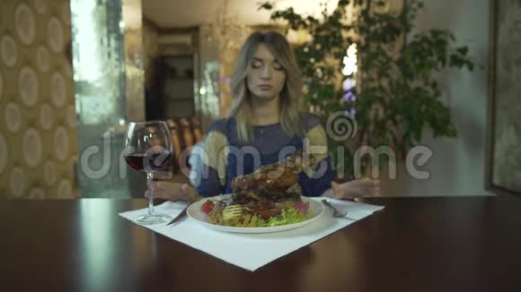 有纹身的年轻女子在高档餐厅里用手等着吃一大块炸肉视频的预览图