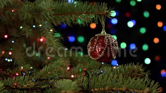 一棵神奇装饰的圣诞树上面有球丝带和红色花环上面有模糊的绿色光泽闪闪发光和仙女视频的预览图