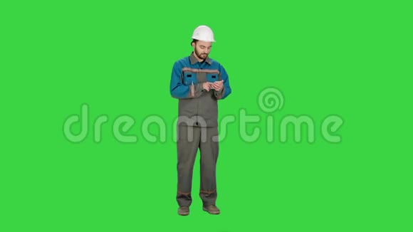 施工人员使用手机在绿色屏幕上发送信息Chroma键视频的预览图