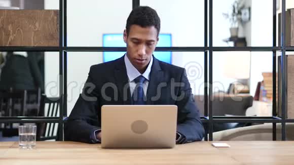 在笔记本电脑工作时被黑人商人打倒视频的预览图