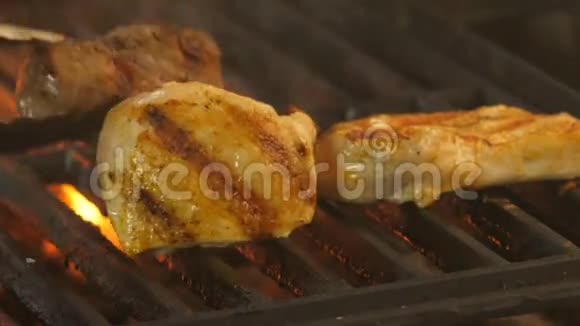 在烤架上放上牛肉和两块鸡片或火鸡的奖章背景是视频的预览图