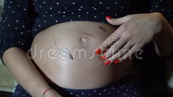 幸福的孕妇躺在沙发上抚摸她的肚子视频的预览图