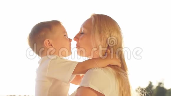快乐的母子在日落时笑着接吻慢动作视频的预览图
