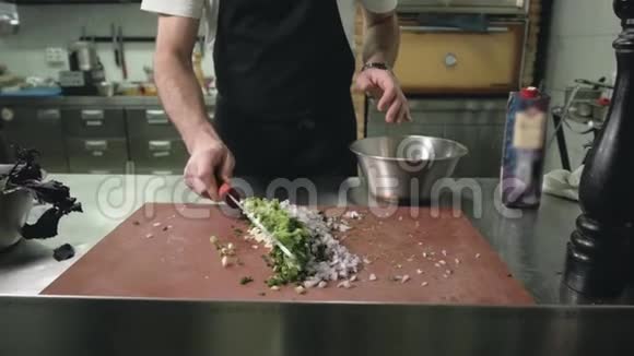 厨师在厨房做饭男式刀在餐厅准备绿色视频的预览图