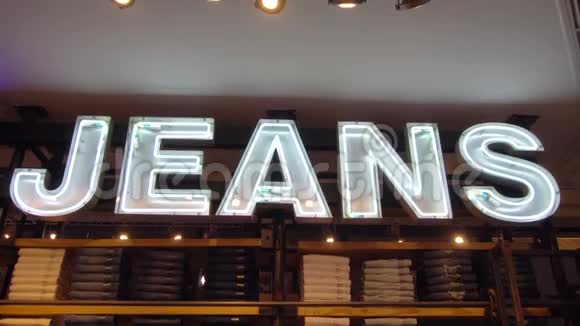 照明的JEANS标志与货架充满牛仔裤垂直盘视频的预览图