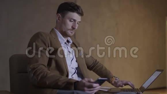 商人正在使用他的手机和笔记本电脑视频的预览图