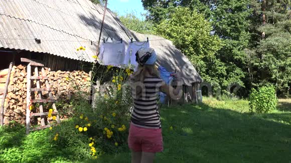 女人挂在绳子上在村院子里洗过童装4K视频的预览图