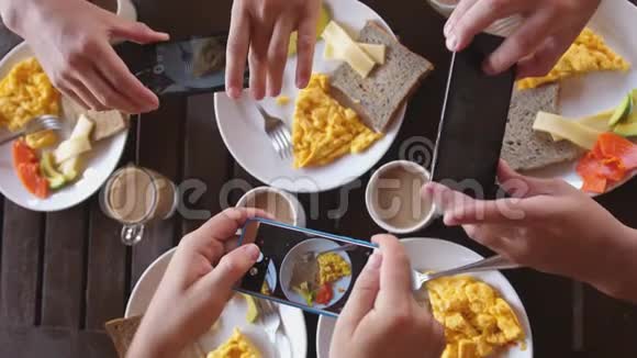 一群朋友在木桌的咖啡馆里吃早餐观看煎蛋烤面包和咖啡的照片视频的预览图