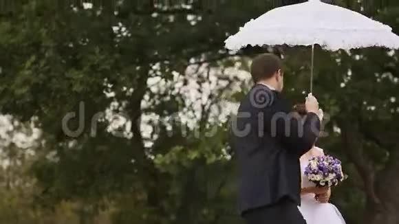 新郎用白色的伞围着新娘转视频的预览图