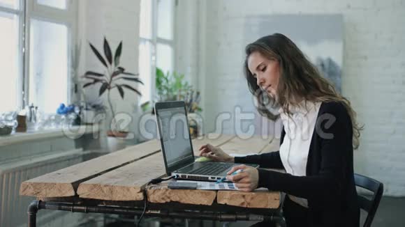 在笔记本电脑旁工作选择颜色的女人视频的预览图