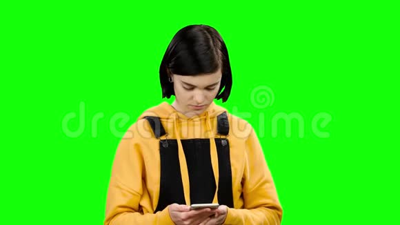 女孩正在她的智能手机上输入一条信息绿色屏幕视频的预览图