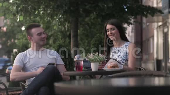 一个女人和一个男人正在夏天的咖啡馆里交谈视频的预览图