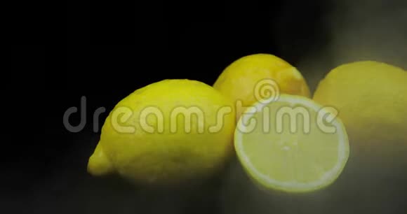 热带水果柠檬在寒冷的冰云中黑色的背景下烟雾视频的预览图