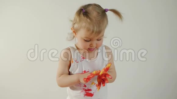 一个涂满油漆的小女孩在地上画着一张白纸视频的预览图