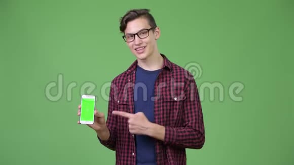 年轻英俊的青少年书呆子男孩展示电话视频的预览图