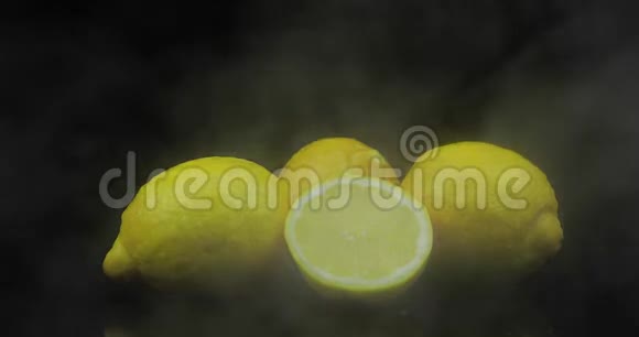 热带水果柠檬在寒冷的冰云中黑色的背景下烟雾视频的预览图