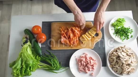 厨房里的披萨晚餐女人用手在木板上切菜的俯视图视频的预览图