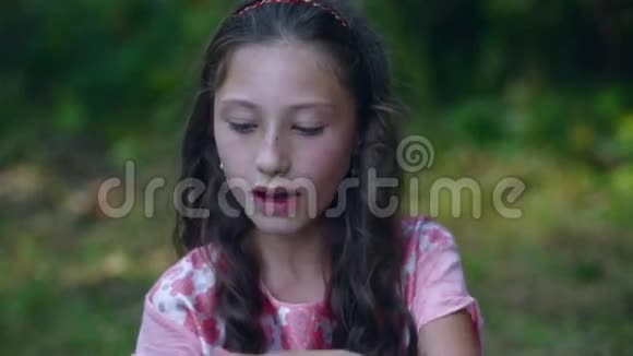 漂亮的小女孩在花园里吃香蕉视频的预览图
